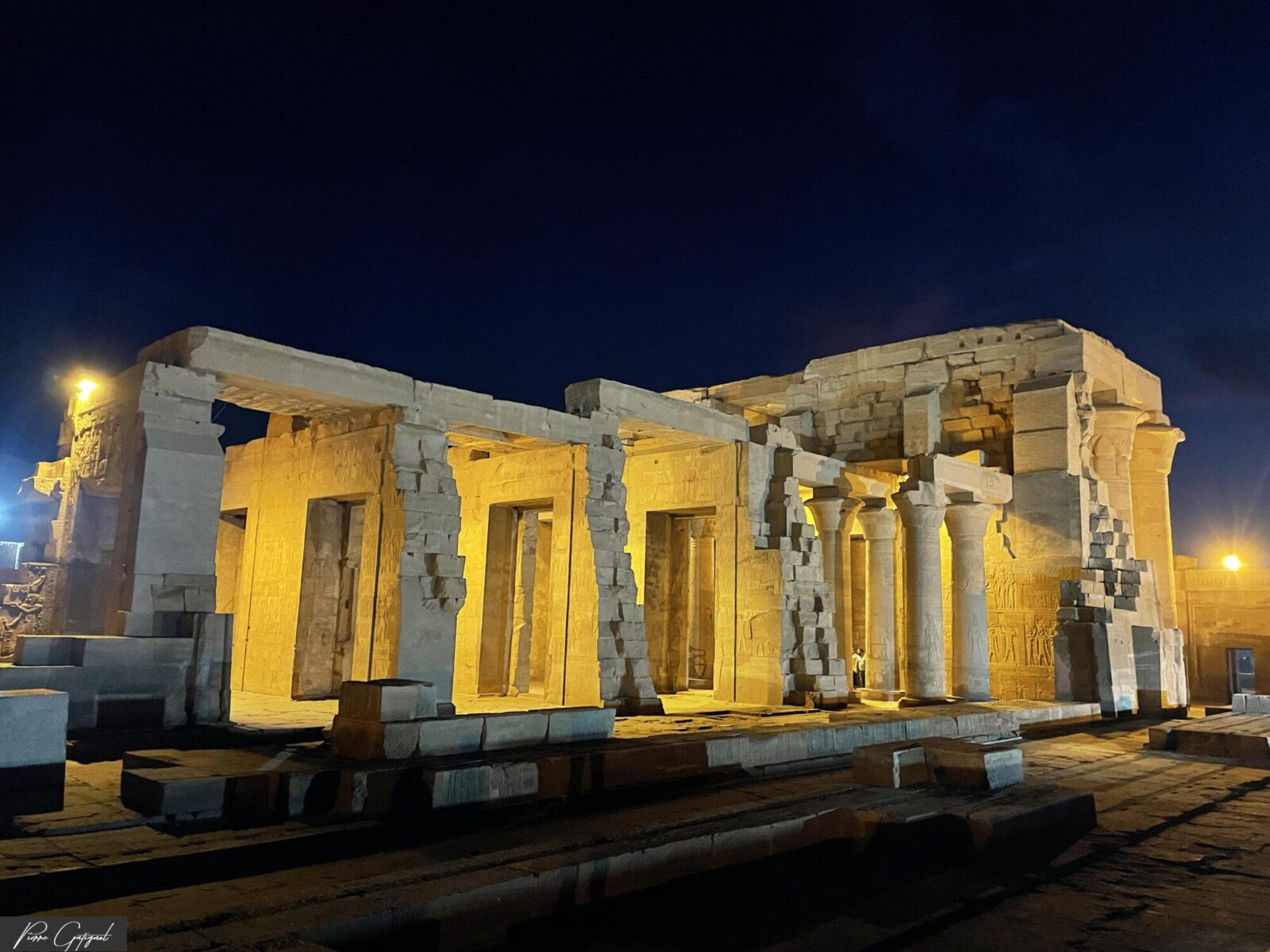 Ruines d’un temple antique éclairées sous un ciel nocturne