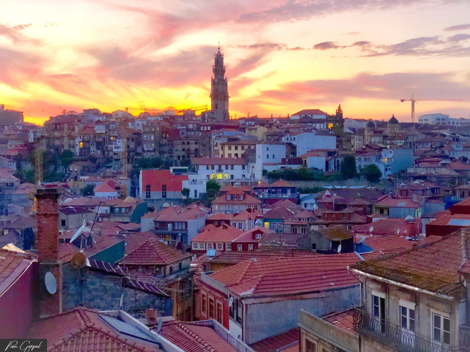 Toits d’une ville et clocher au coucher du soleil
