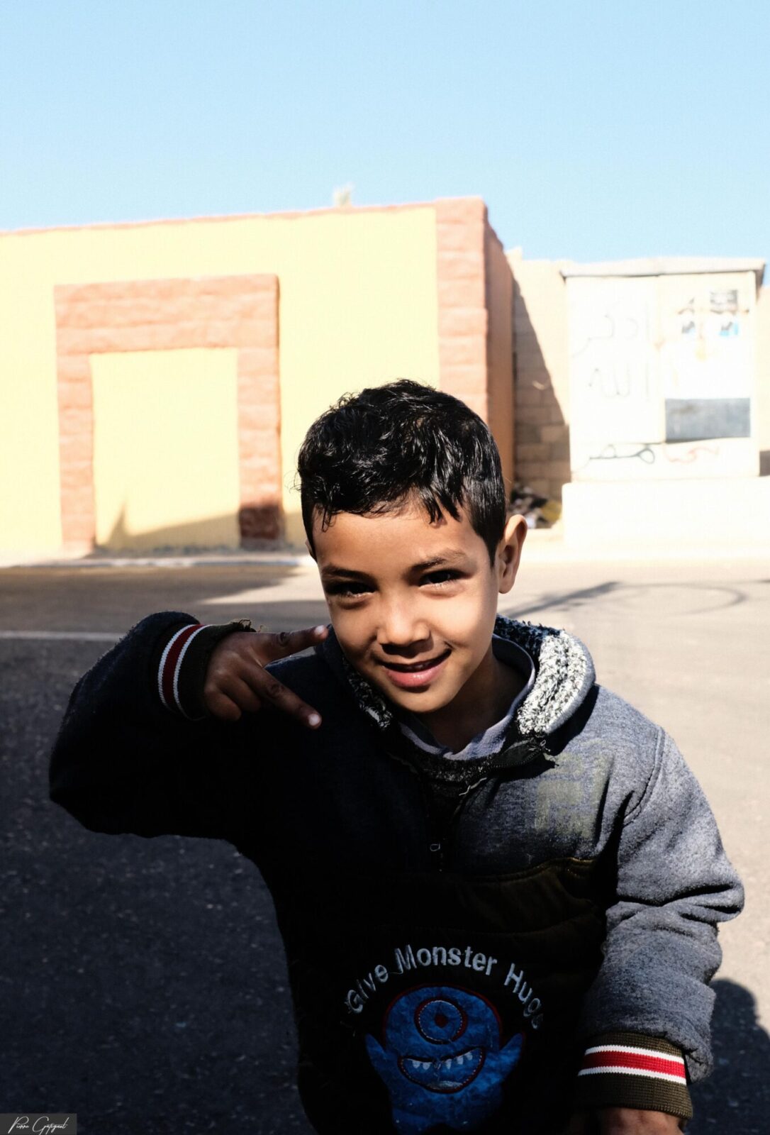 Jeune garçon souriant et faisant un geste de la main