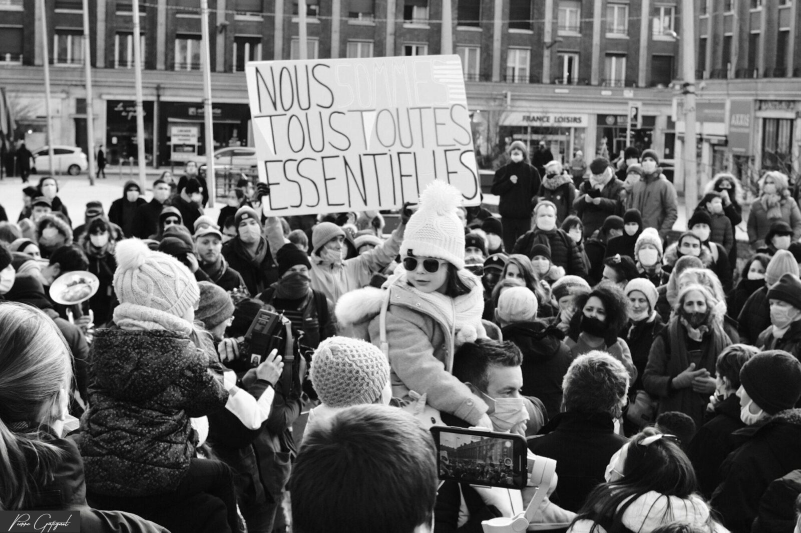 Foule rassemblée autour d’une pancarte « Nous sommes toutes essentielles »