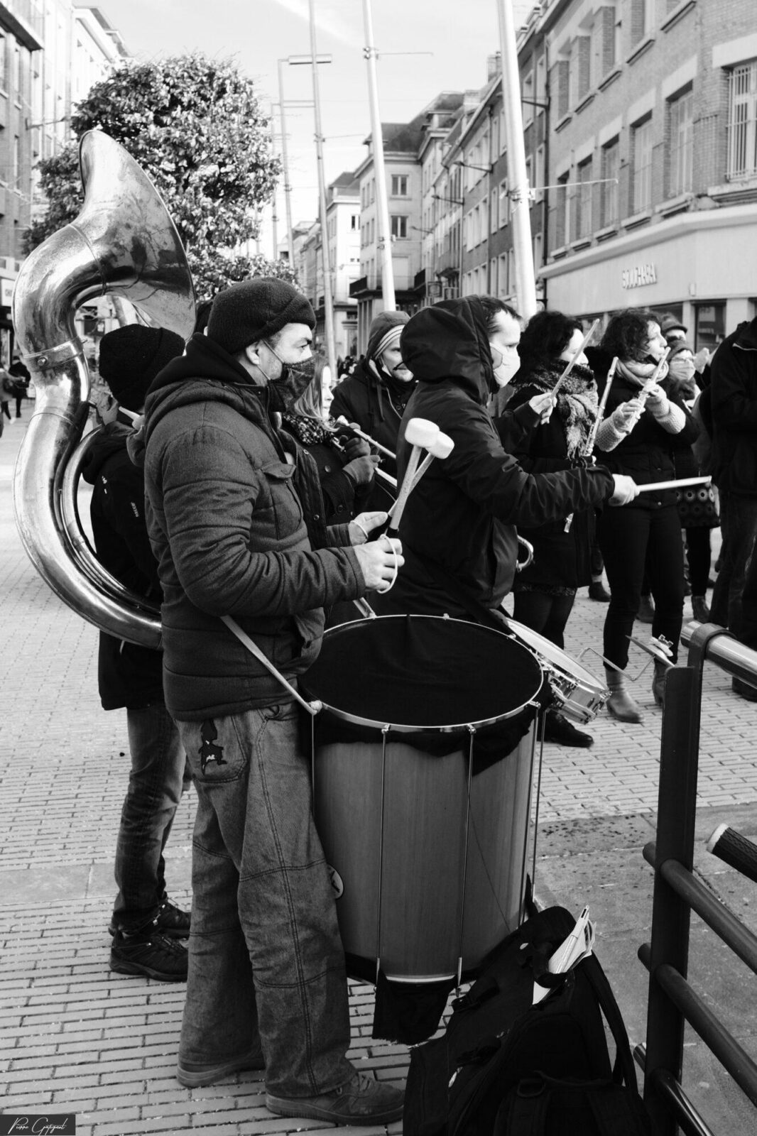 Musiciens jouant des cuivres et percussions dans une rue