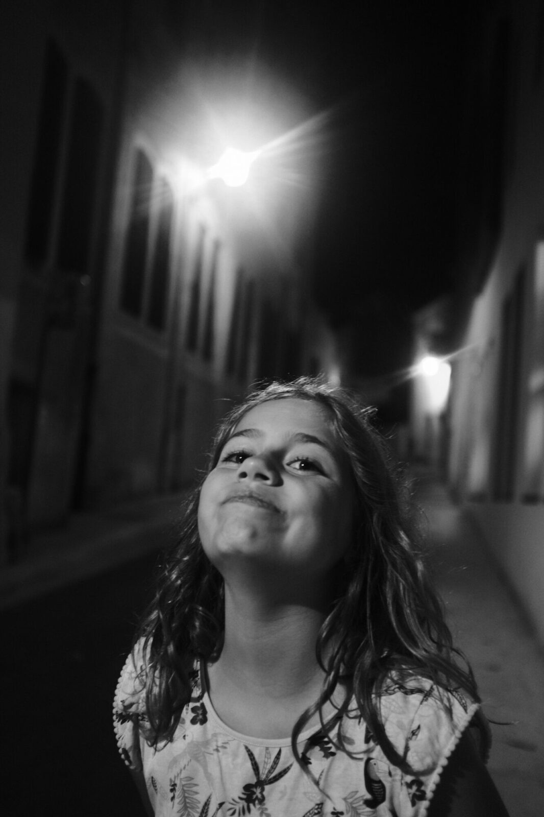 Jeune fille souriante dans une ruelle éclairée la nuit