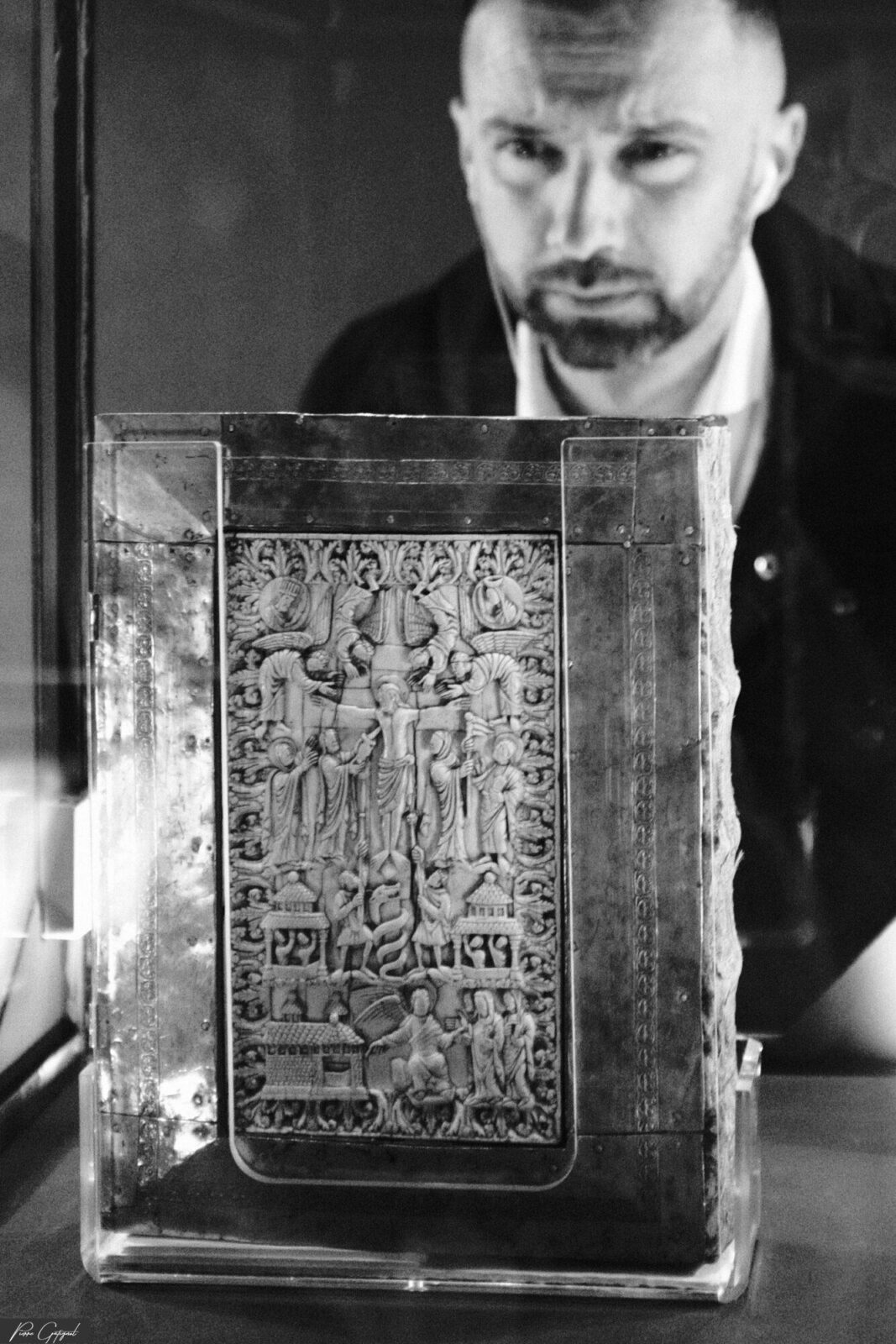 Homme derrière un livre ancien ouvert posé sur une table