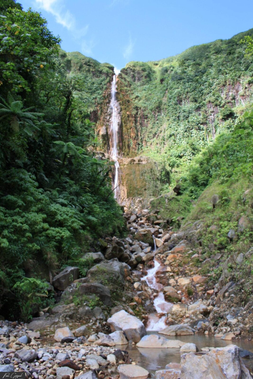 Cascade au fond d’une vallée rocheuse et verdoyante