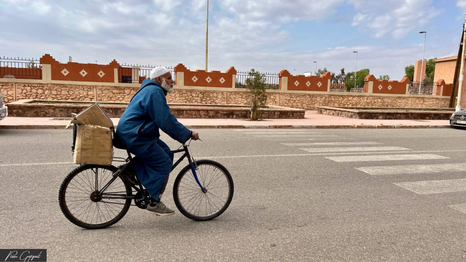 Homme à vélo transportant un panier sur une avenue