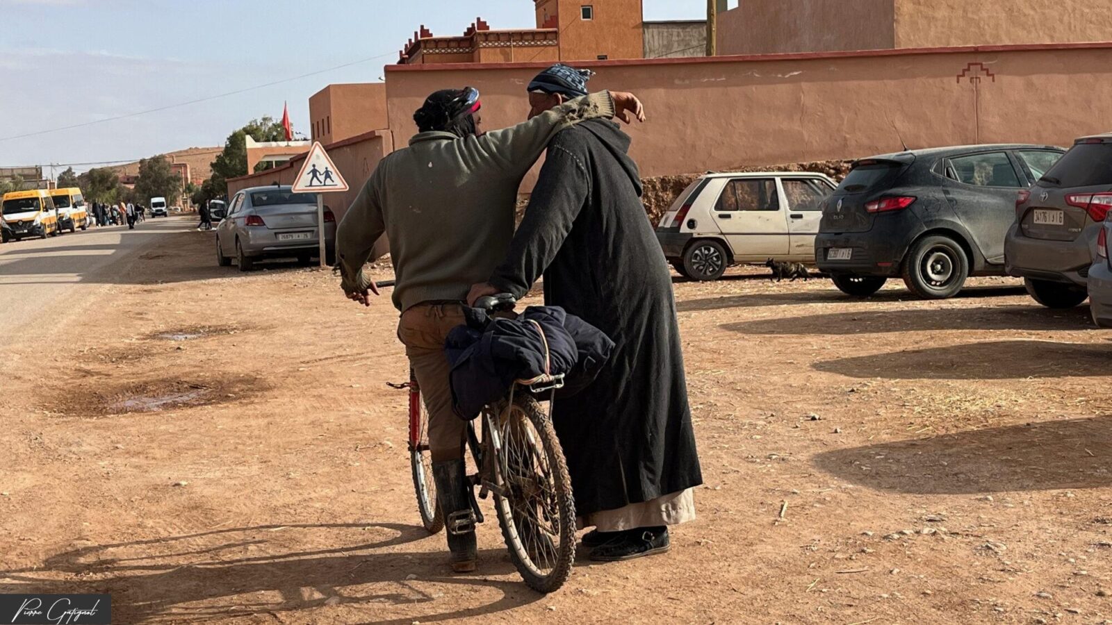 Deux hommes marchant avec un vélo dans une rue