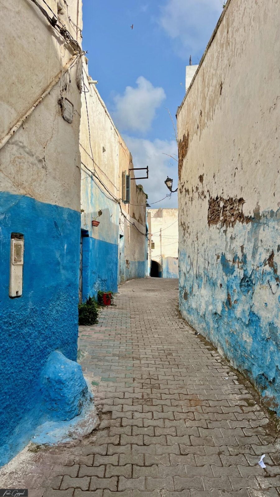 Ruelle étroite bordée de murs blancs et bleus