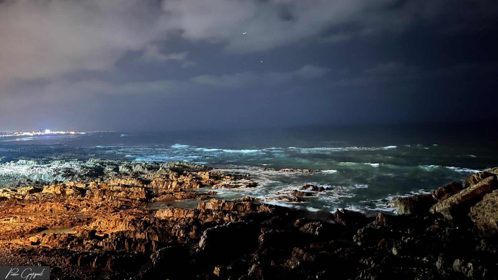 Vagues nocturnes sur une côte rocheuse éclairée