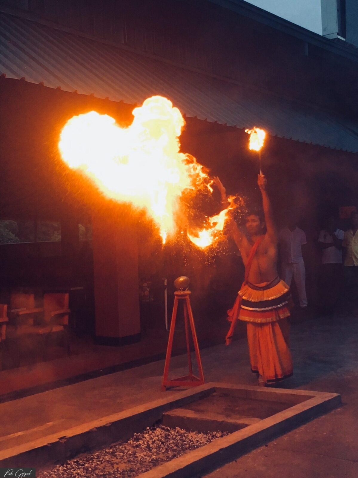 Artiste réalisant un numéro de feu devant des spectateurs.