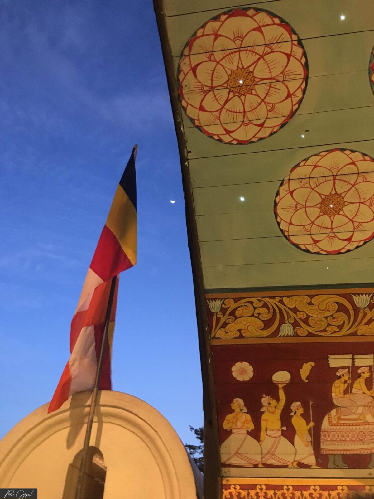 Drapeau multicolore sous un plafond peint de motifs circulaires