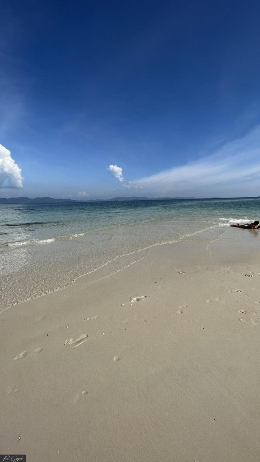 Plage de sable clair, mer calme et ciel bleu
