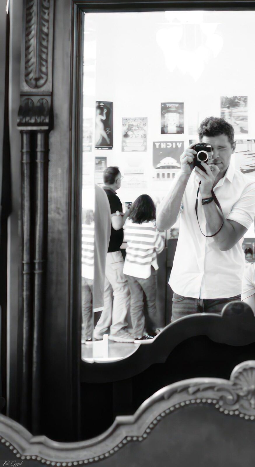 Photographe tenant son appareil devant un miroir