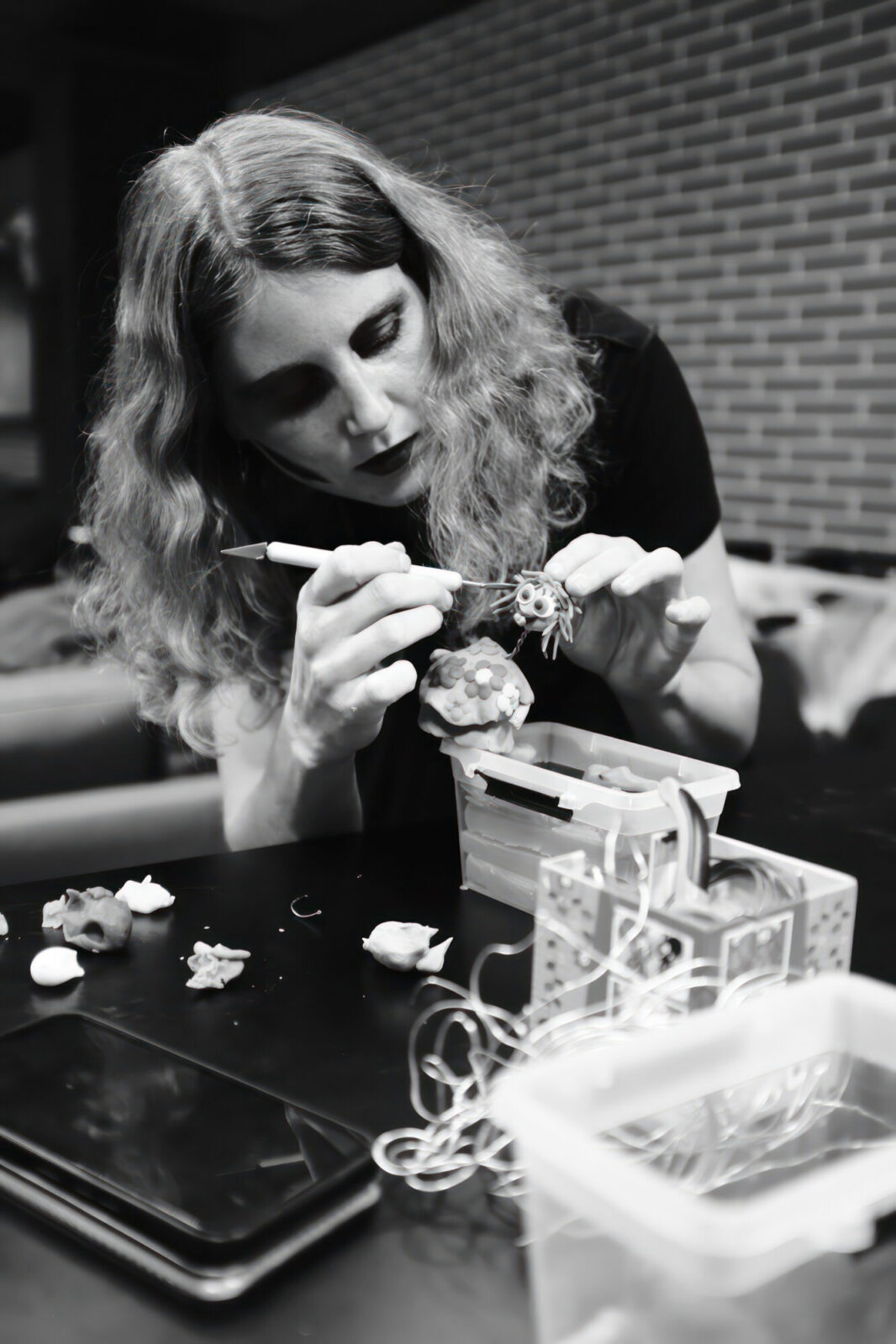 Femme peignant une petite figurine avec un pinceau
