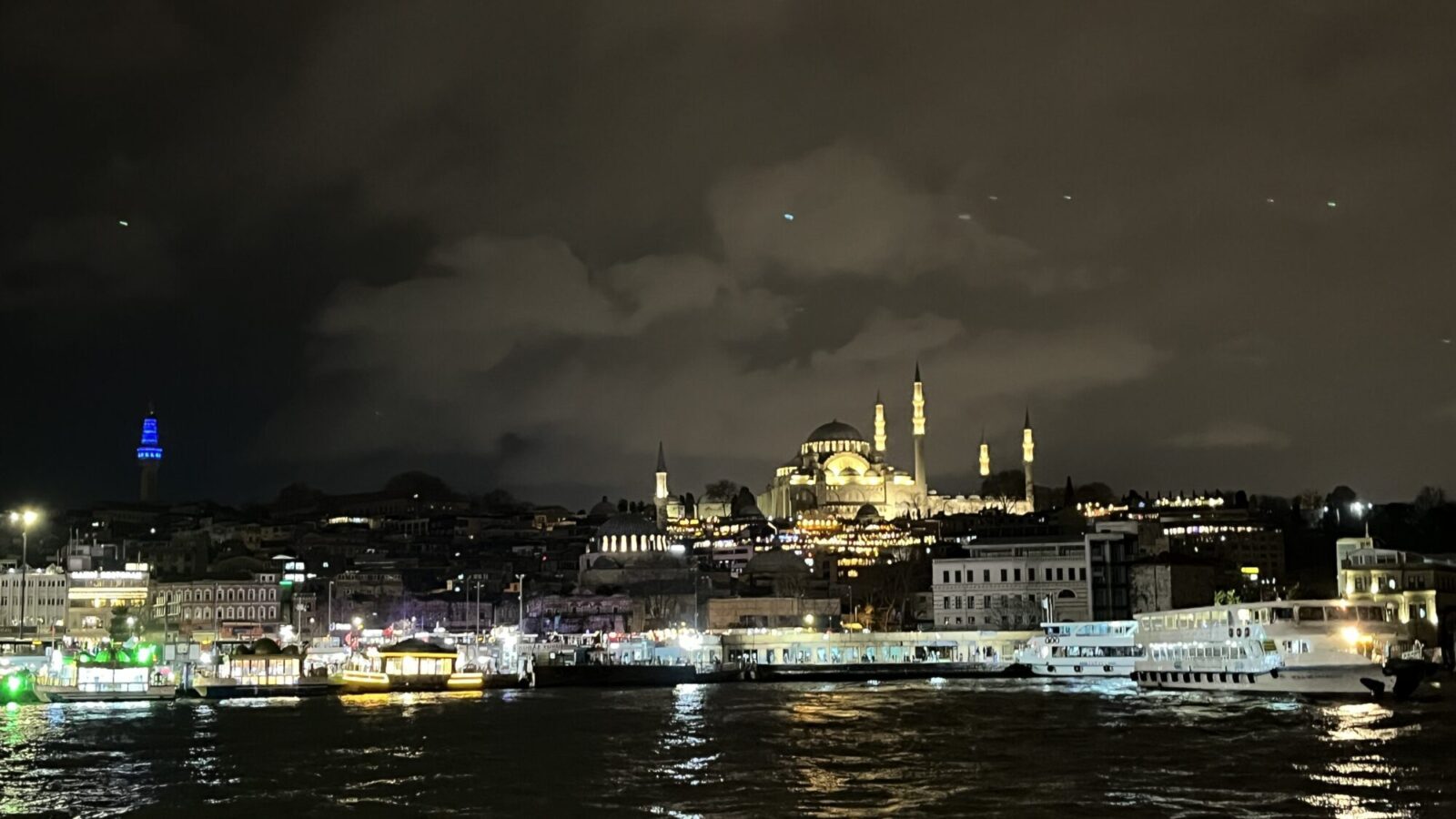 Mosquée illuminée dominant les rives et le fleuve la nuit