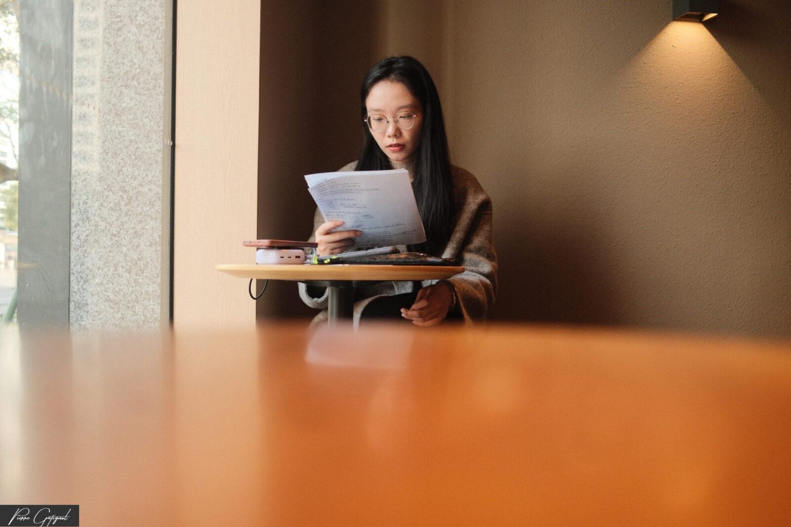Femme lisant des documents à une table de café