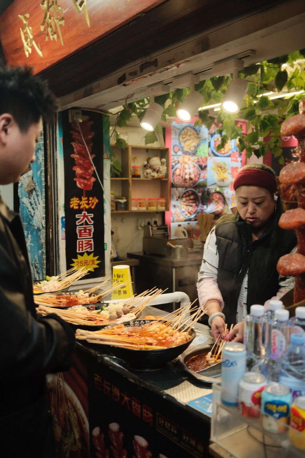 Vendeuse préparant des brochettes devant un client