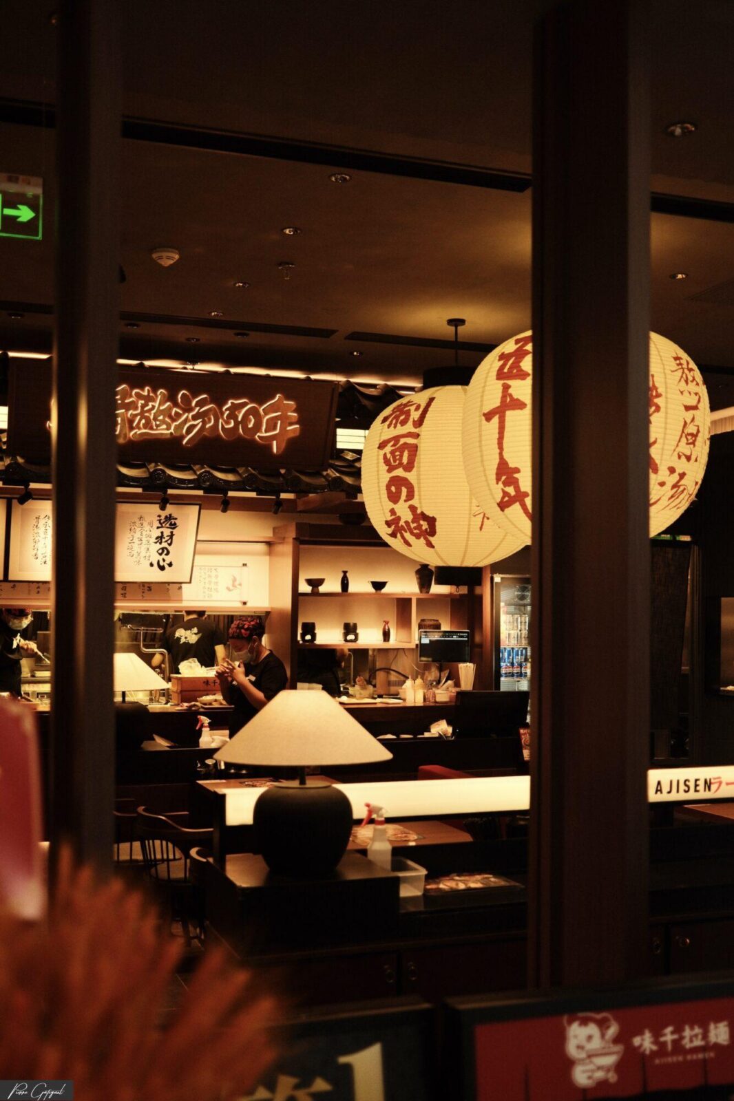 Lanternes suspendues visibles à travers la vitre d’un restaurant asiatique