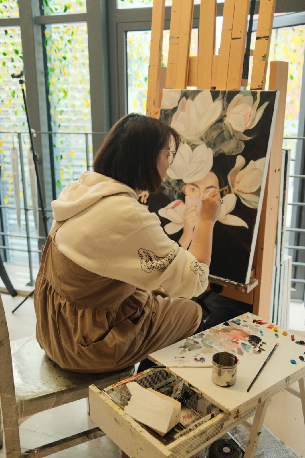 Artiste peignant des fleurs sur une toile posée sur un chevalet