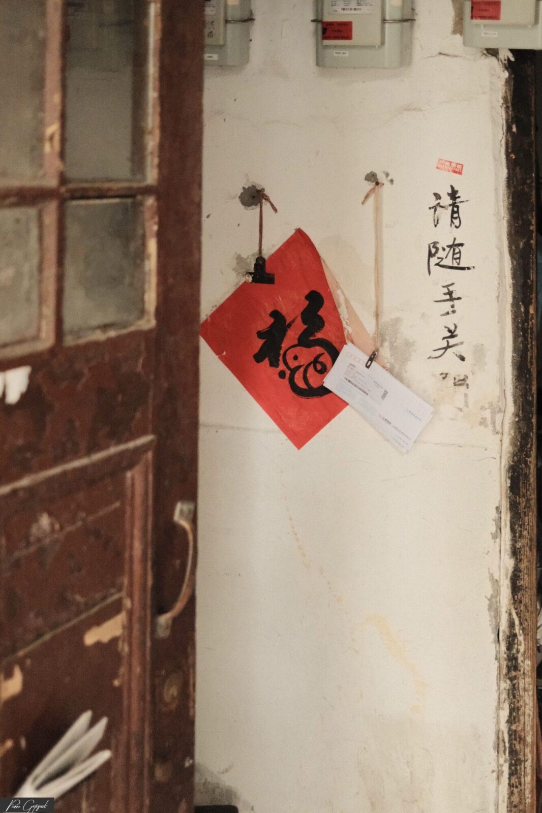 Porte ancienne et mur avec calligraphie chinoise et losange rouge