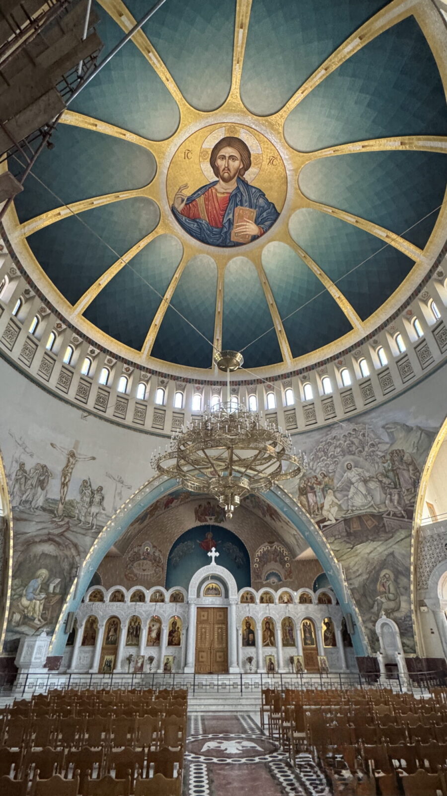 Nef d’une église orthodoxe avec coupole peinte et lustre central