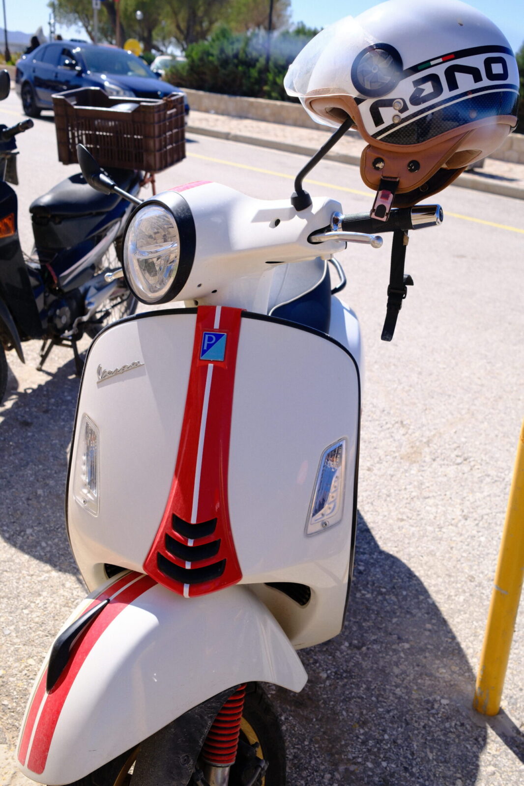 Scooter blanc avec casque posé sur le rétroviseur