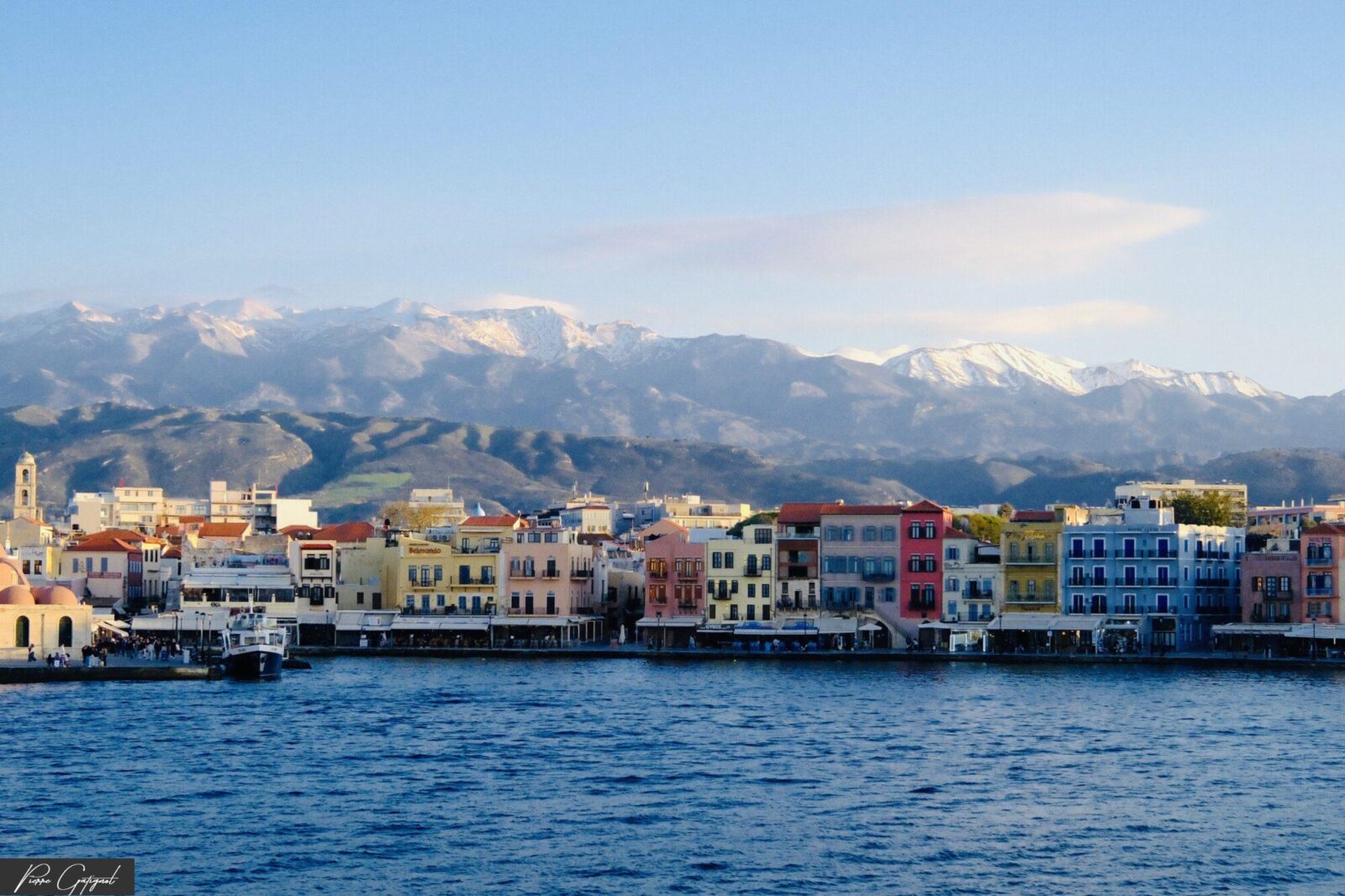 Façades colorées au bord de l’eau devant des montagnes enneigées