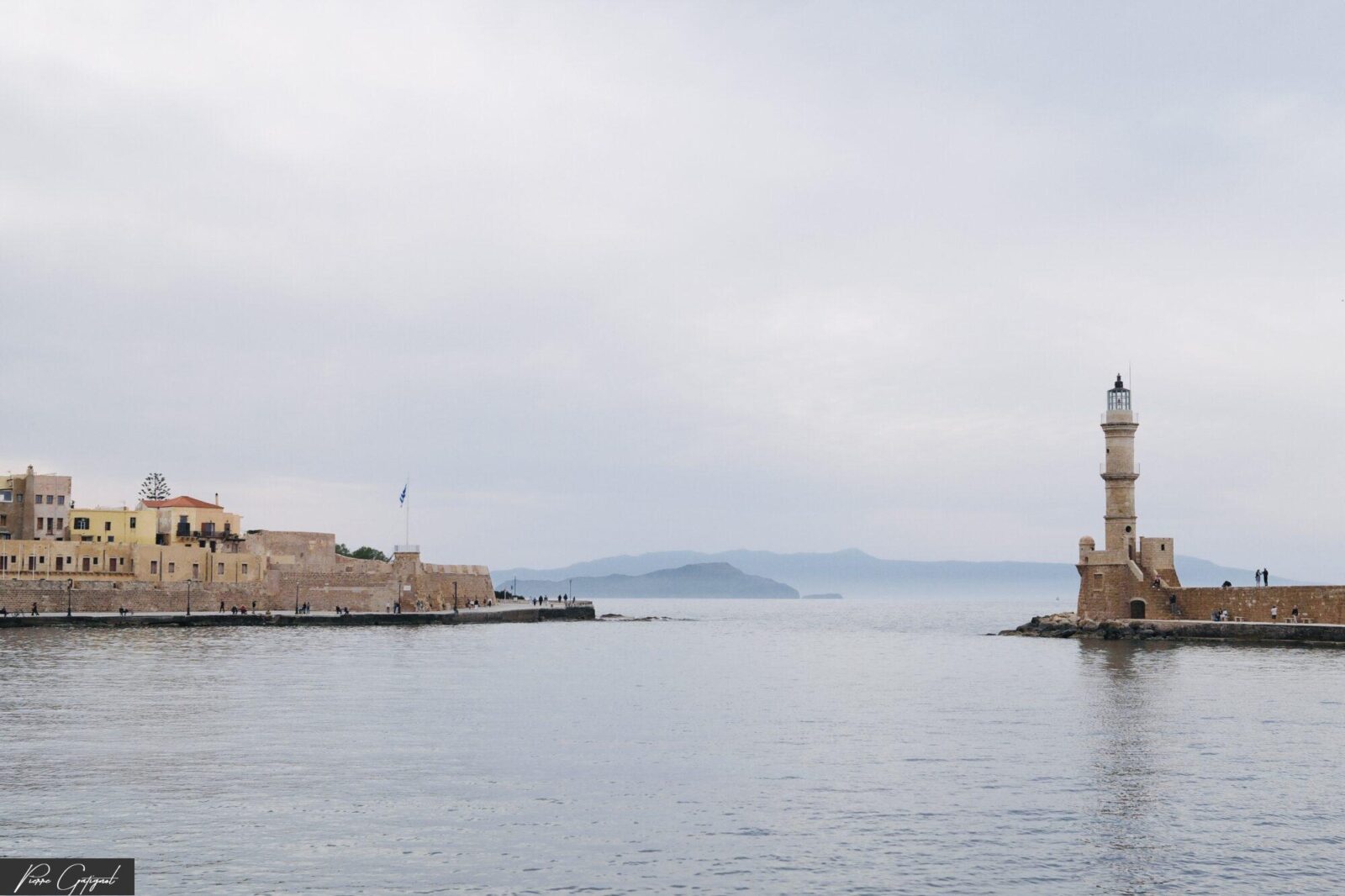 Phare à l’entrée d’un port, face à la mer calme